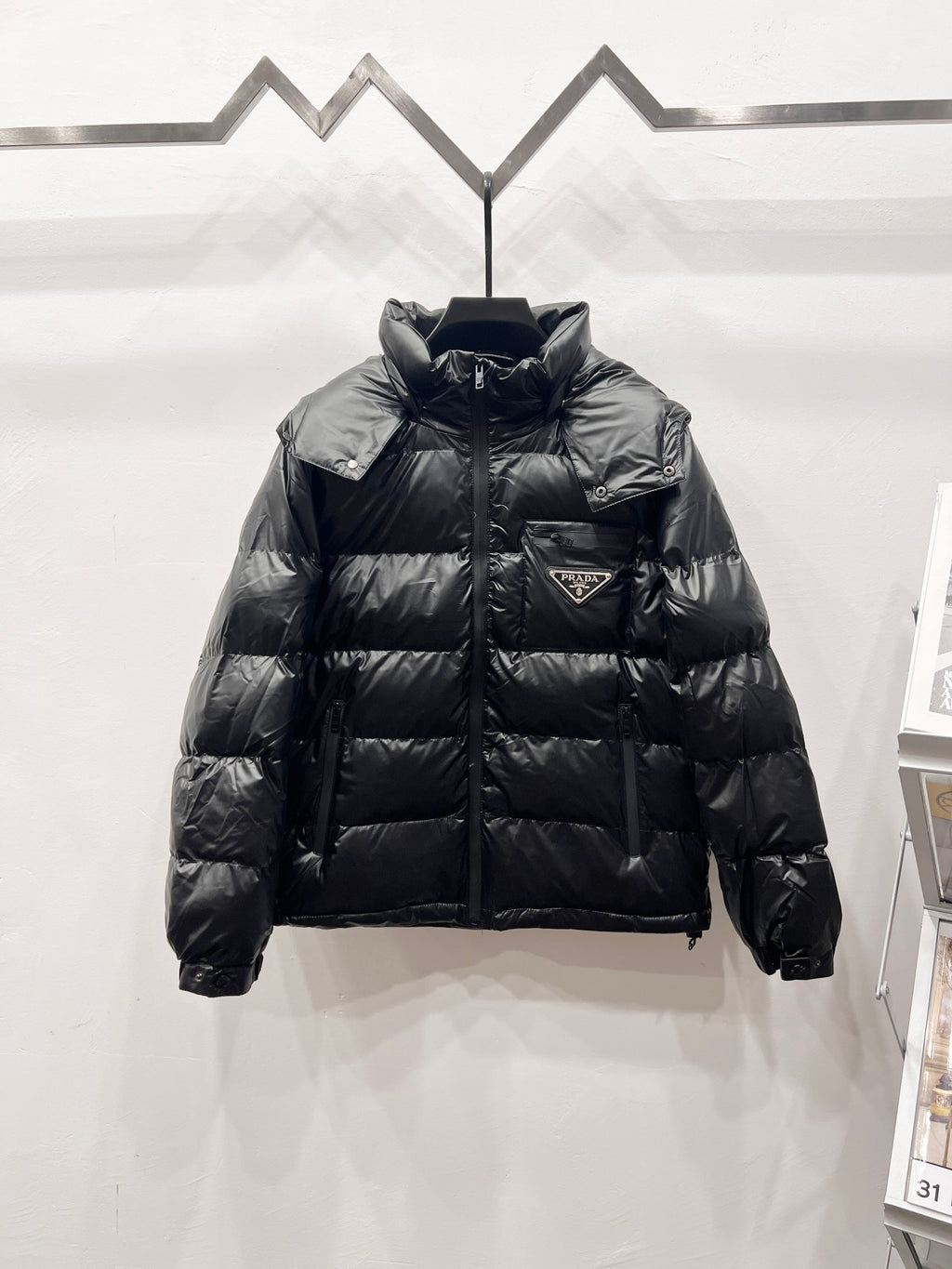 Black long puffer jacket with high collar, zip front, and quilted baffles