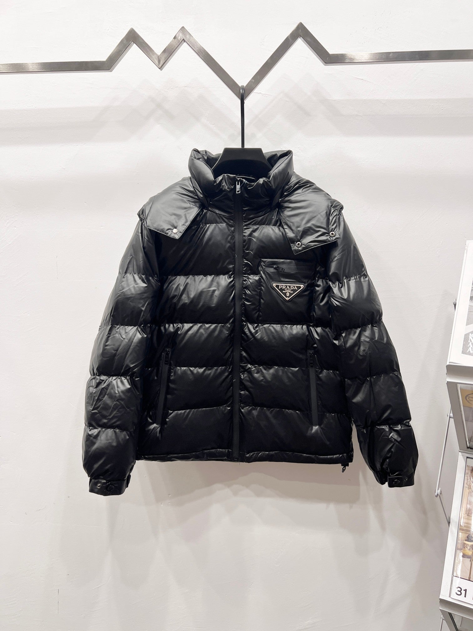 Black long puffer jacket with high collar, zip front, and quilted baffles