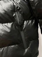Black long puffer jacket side view with zip seam and quilted panels