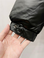 Black puffer jacket cuff with snap button and round metal hardware
