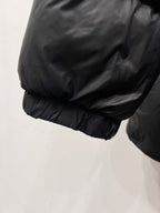 Dark puffer jacket sleeve cuff and rounded hem