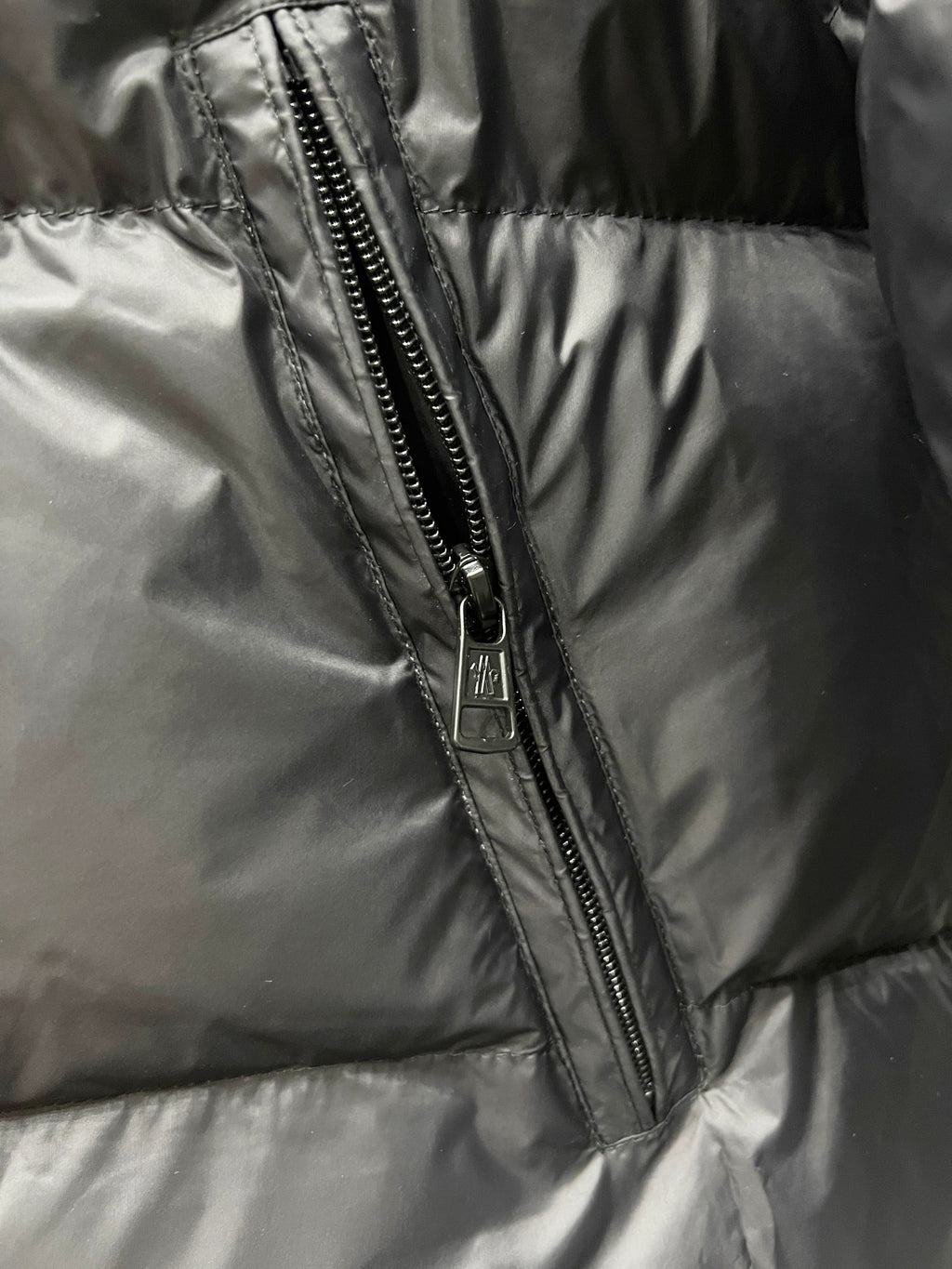 Front zipper seam on dark quilted puffer jacket