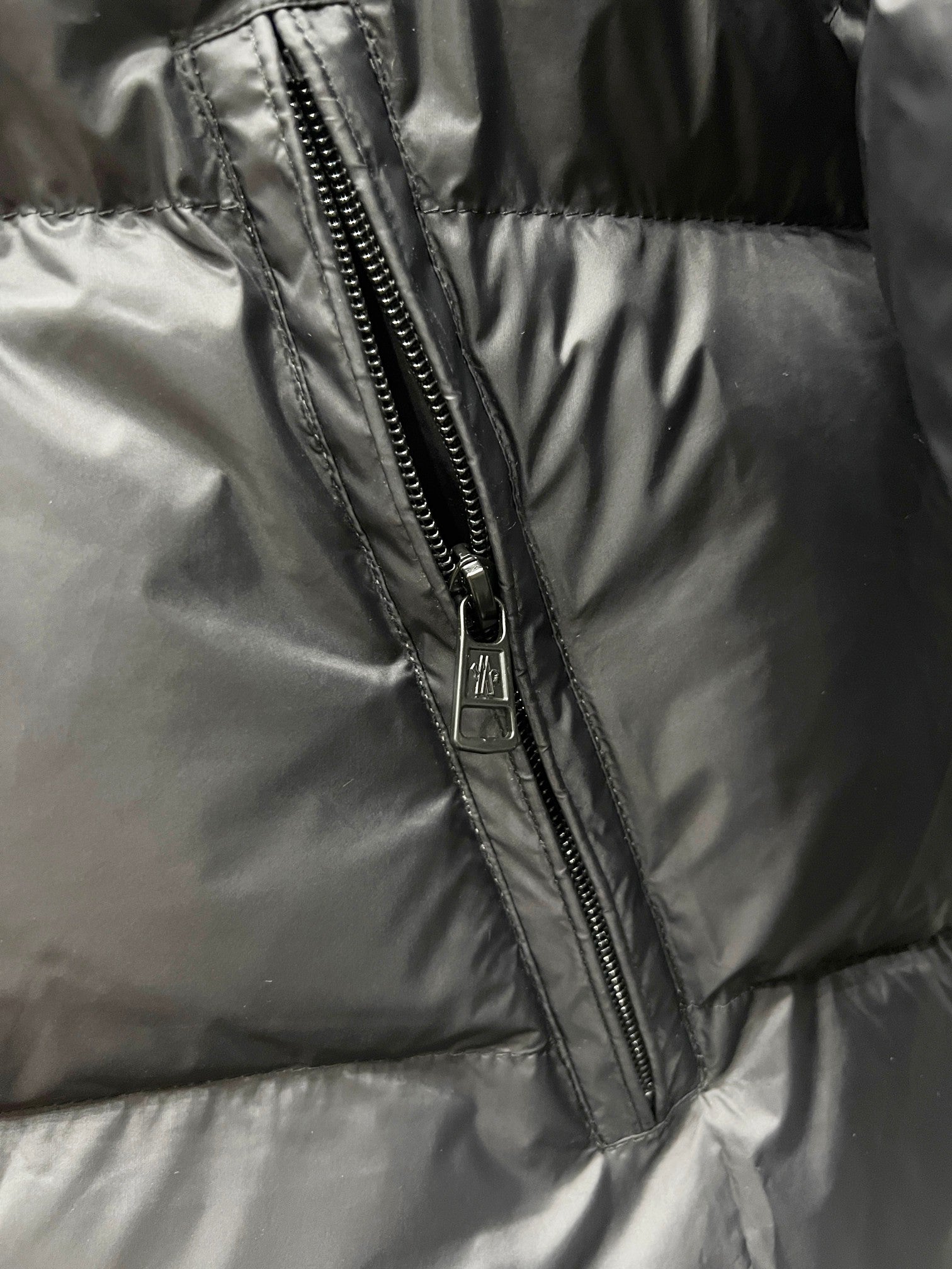 Front zipper seam on dark quilted puffer jacket