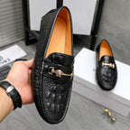 Black leather loafer with embossed finish, gold-tone buckle bar, and tan interior.