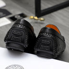 Black leather loafer heel and sole detail with embossed grip pads.