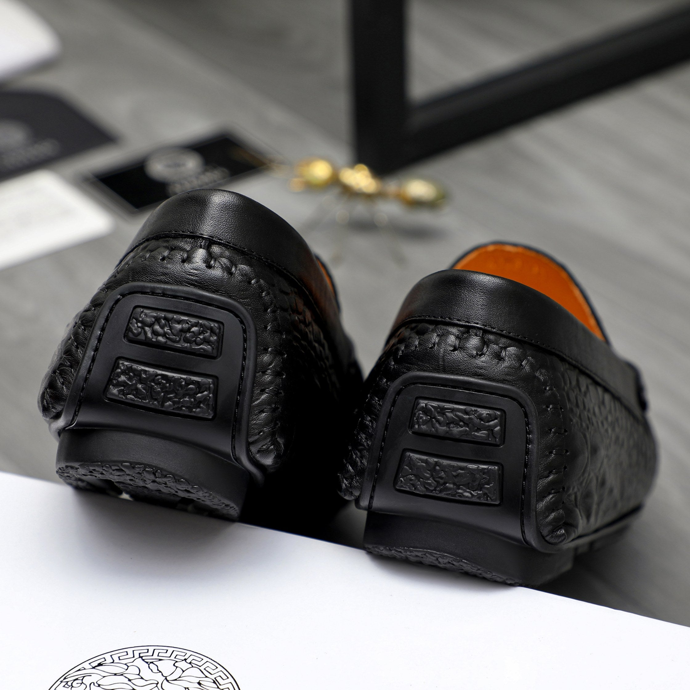 Black leather loafer heel and sole detail with embossed grip pads.