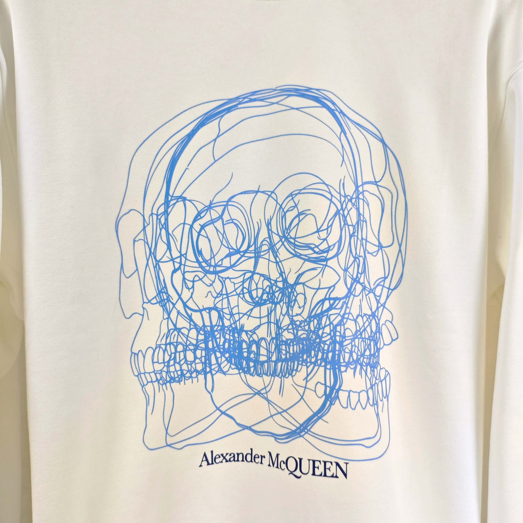 White sweatshirt with large blue line-art skull graphic and Alexander McQUEEN text
