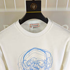 White crewneck sweatshirt with ribbed collar and blue skull graphic, close-up