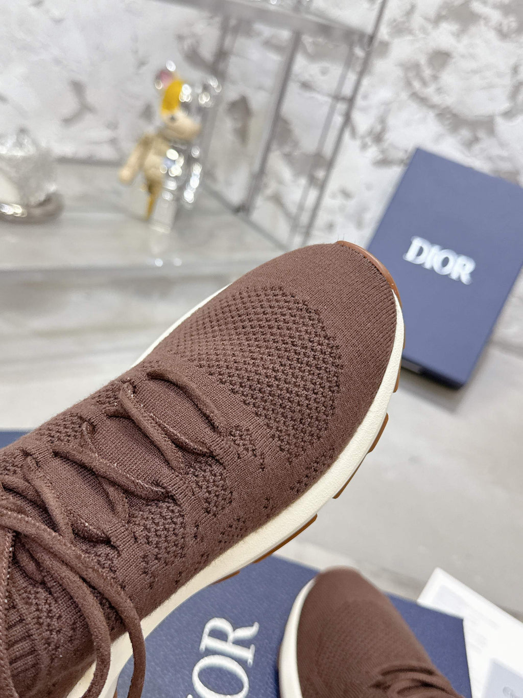 Brown knit sneaker toe with lace-up closure and white sole edge