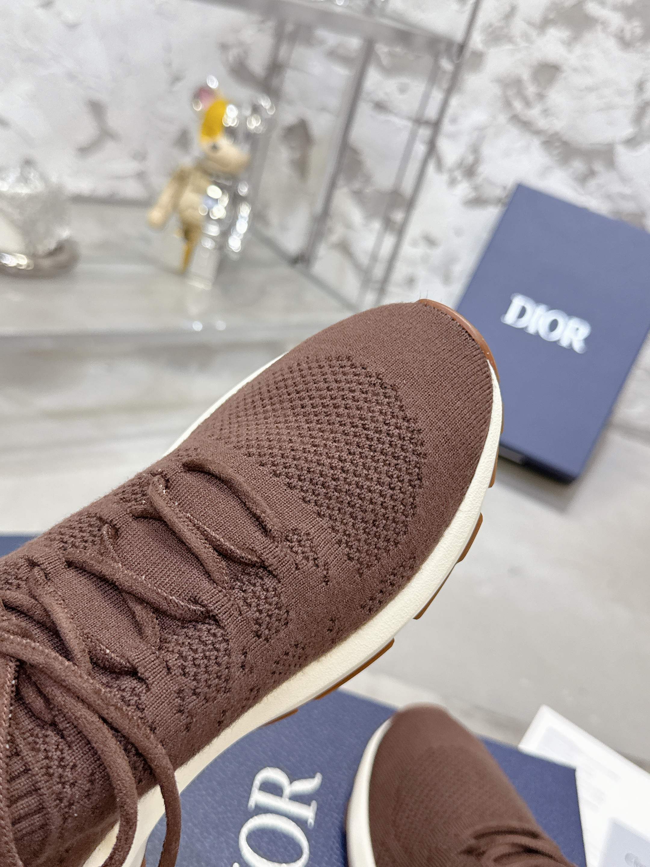 Brown knit sneaker toe with lace-up closure and white sole edge