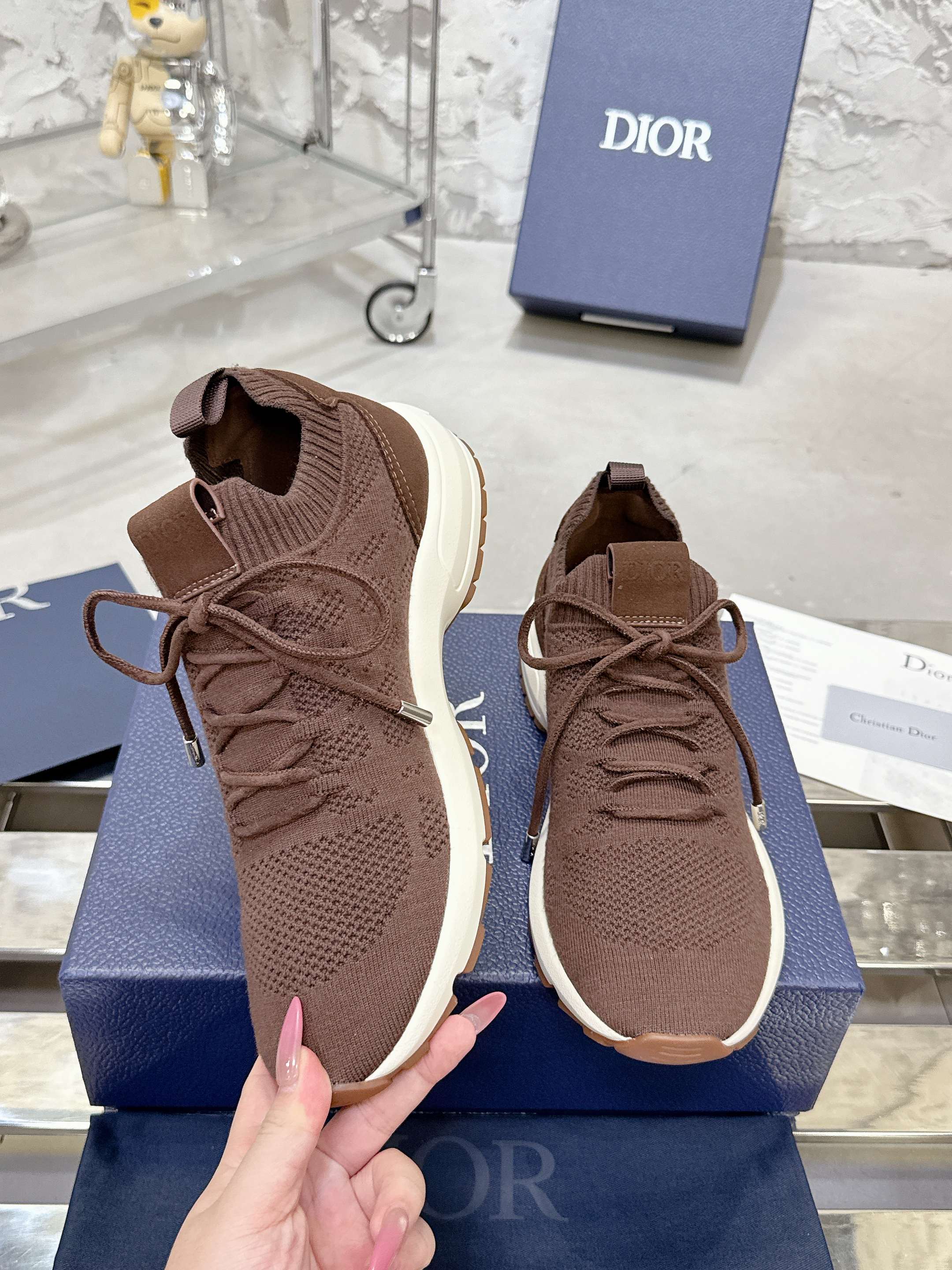 Brown knit sneakers with lace-up closures and white rubber soles
