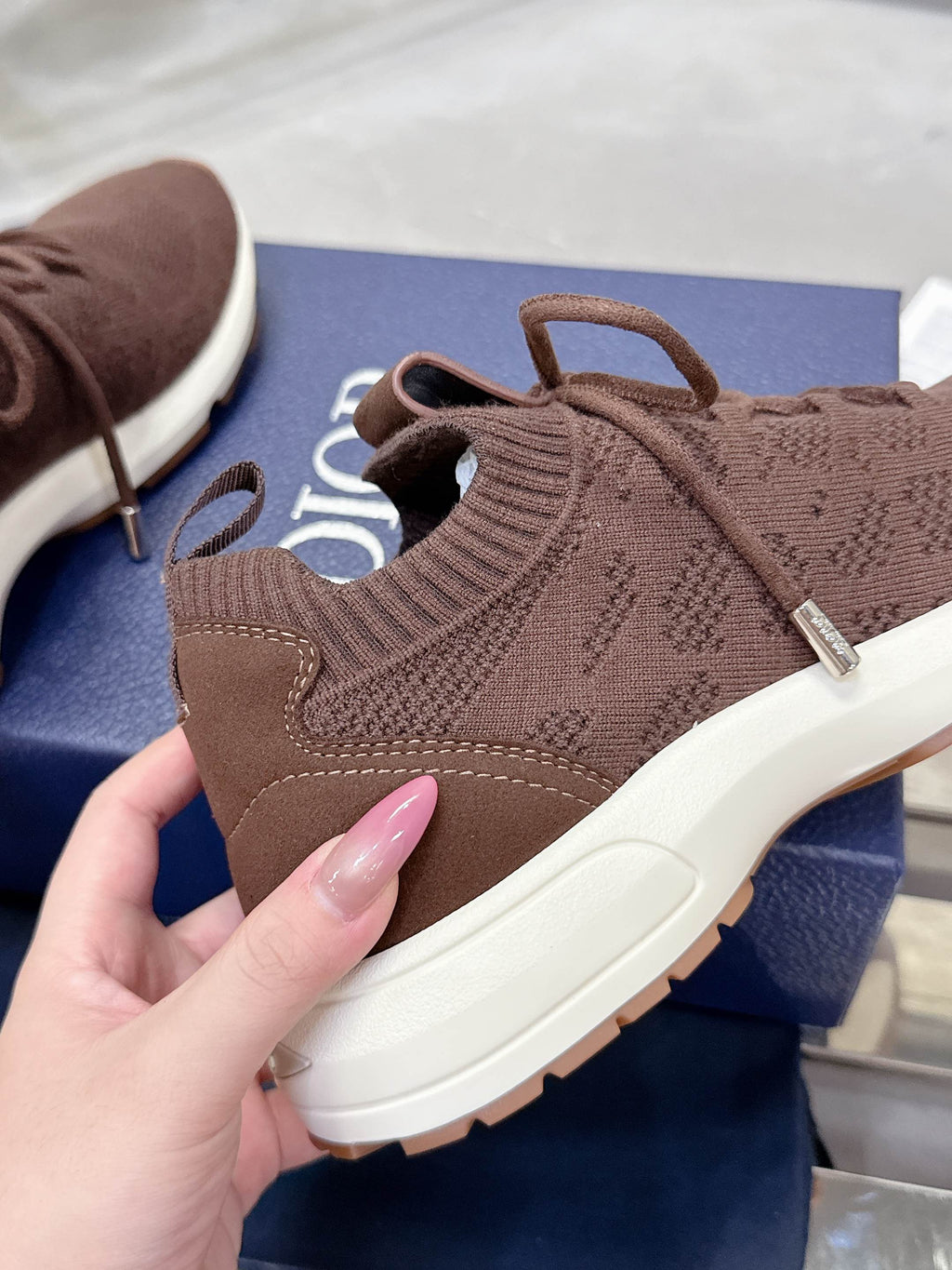 Brown sock-style knit sneaker with laces and cushioned white sole