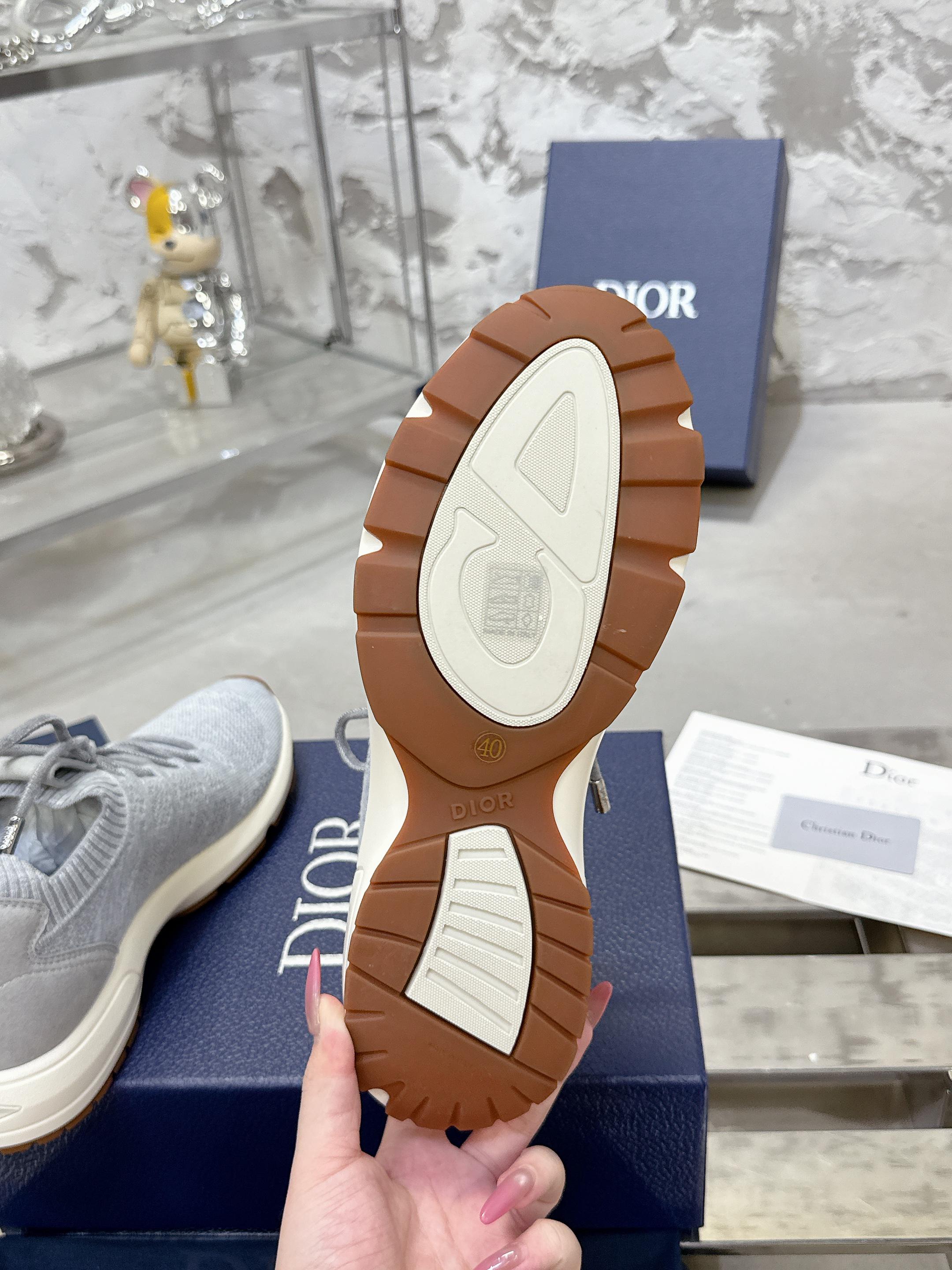 Sneaker outsole view with brown rubber tread on blue Dior box