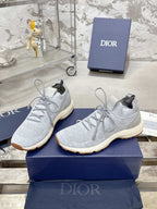 Pair of light gray textured sneakers with white laces and tan soles