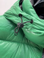 Green puffer vest hood with black drawstring cords and round toggle detail
