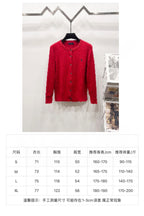 Red cable-knit button cardigan sweater on hanger; size chart panel below