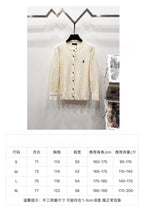 Cream knit cardigan with button front and size chart table listing measurements