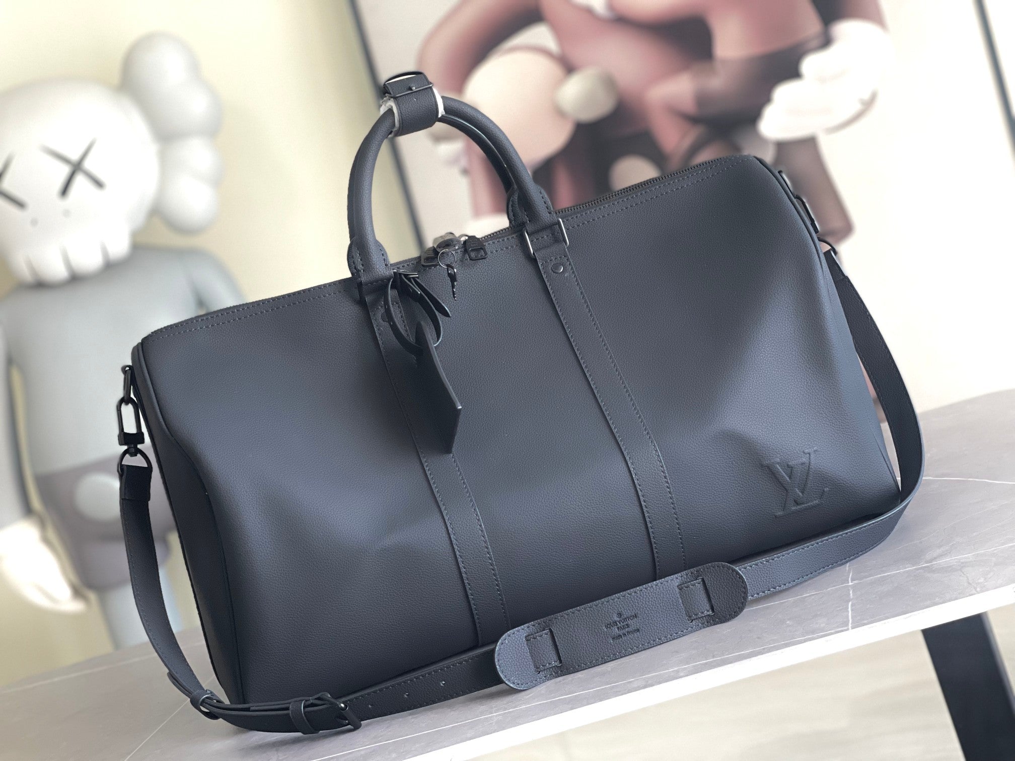 Louis Vuitton bag with top handles and side zip, dark smooth leather.