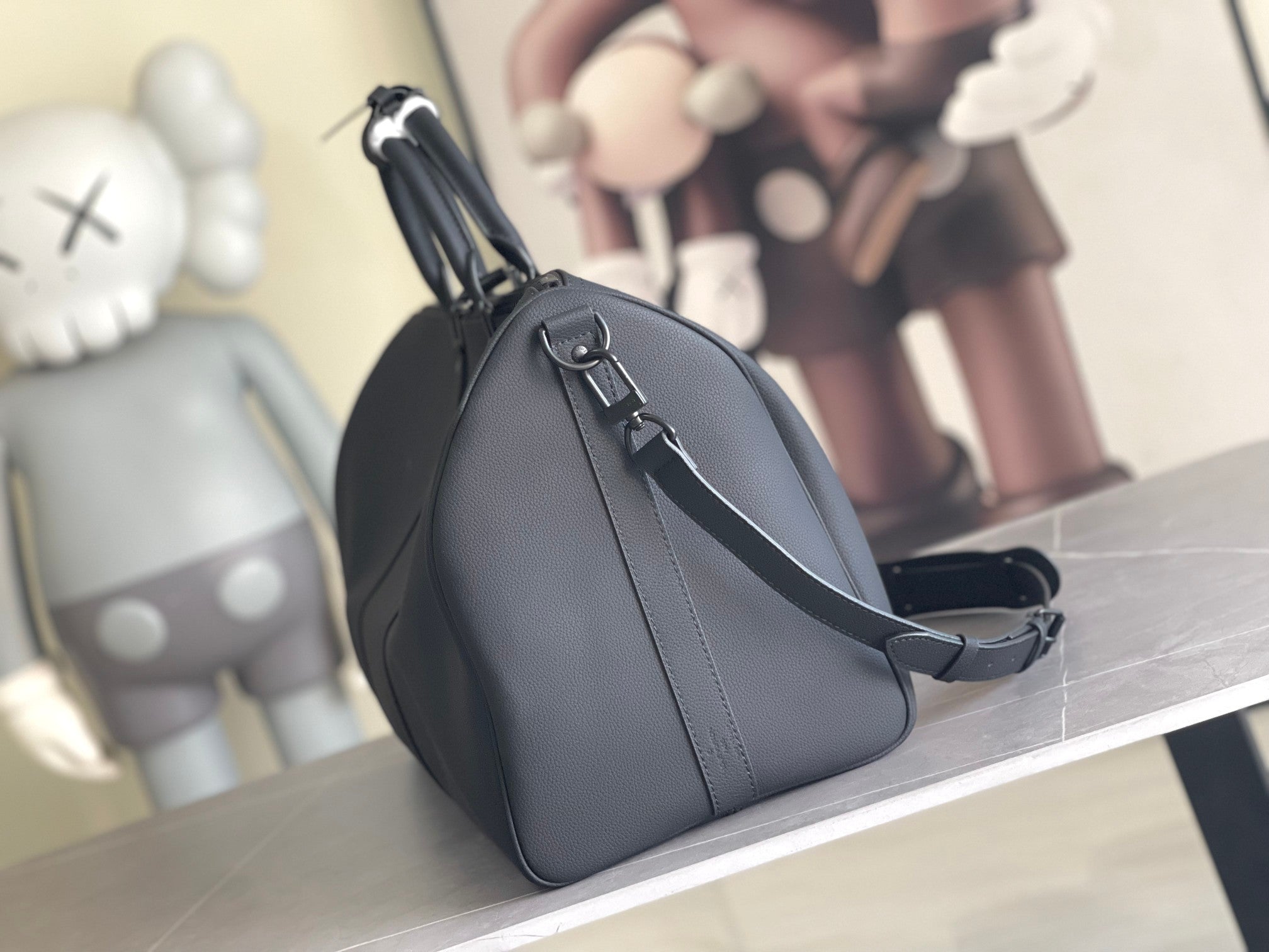 Men's Louis Vuitton duffel bag with curved top handle and adjustable shoulder strap