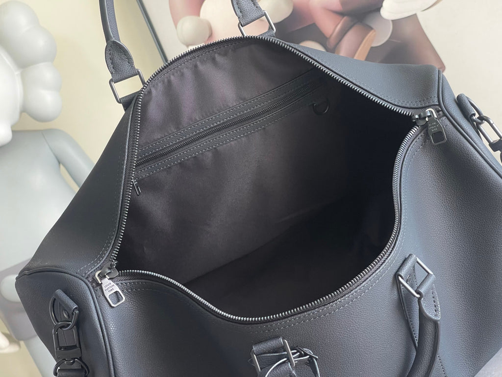 Louis Vuitton bag interior view with zip pocket and metal emblem on front panel.