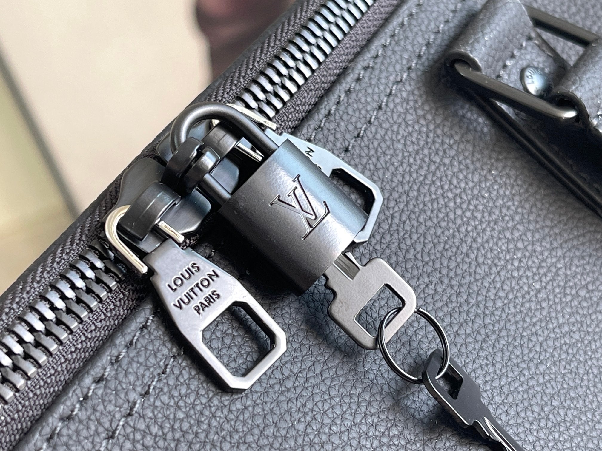 Louis Vuitton duffel bag zipper and keychain hardware with engraved metal tags