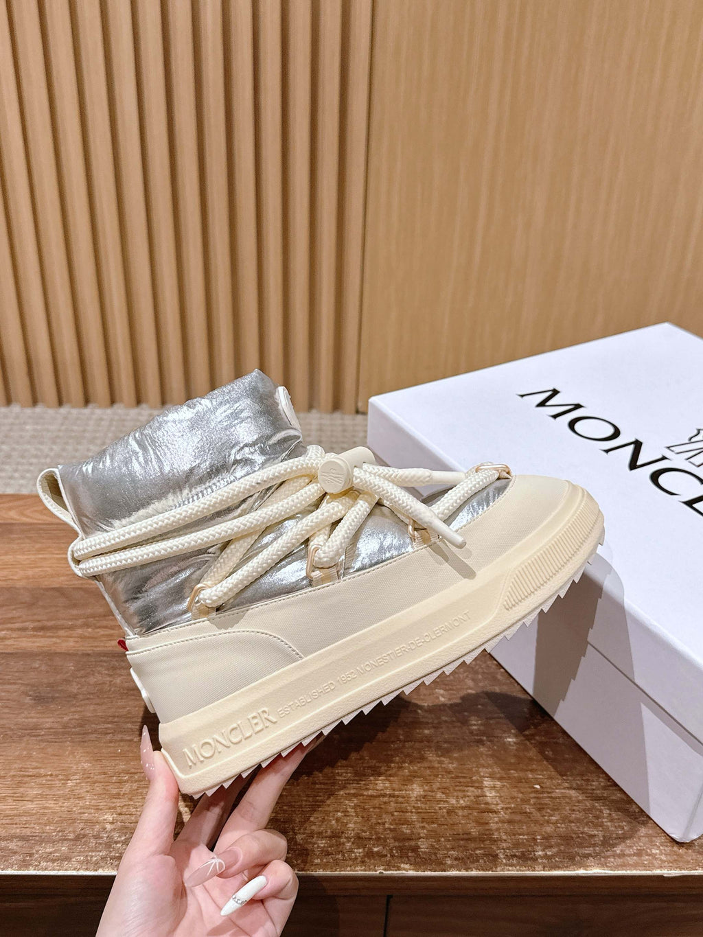 Moncler lace-up sneaker boots with silver uppers and cream laces, held close