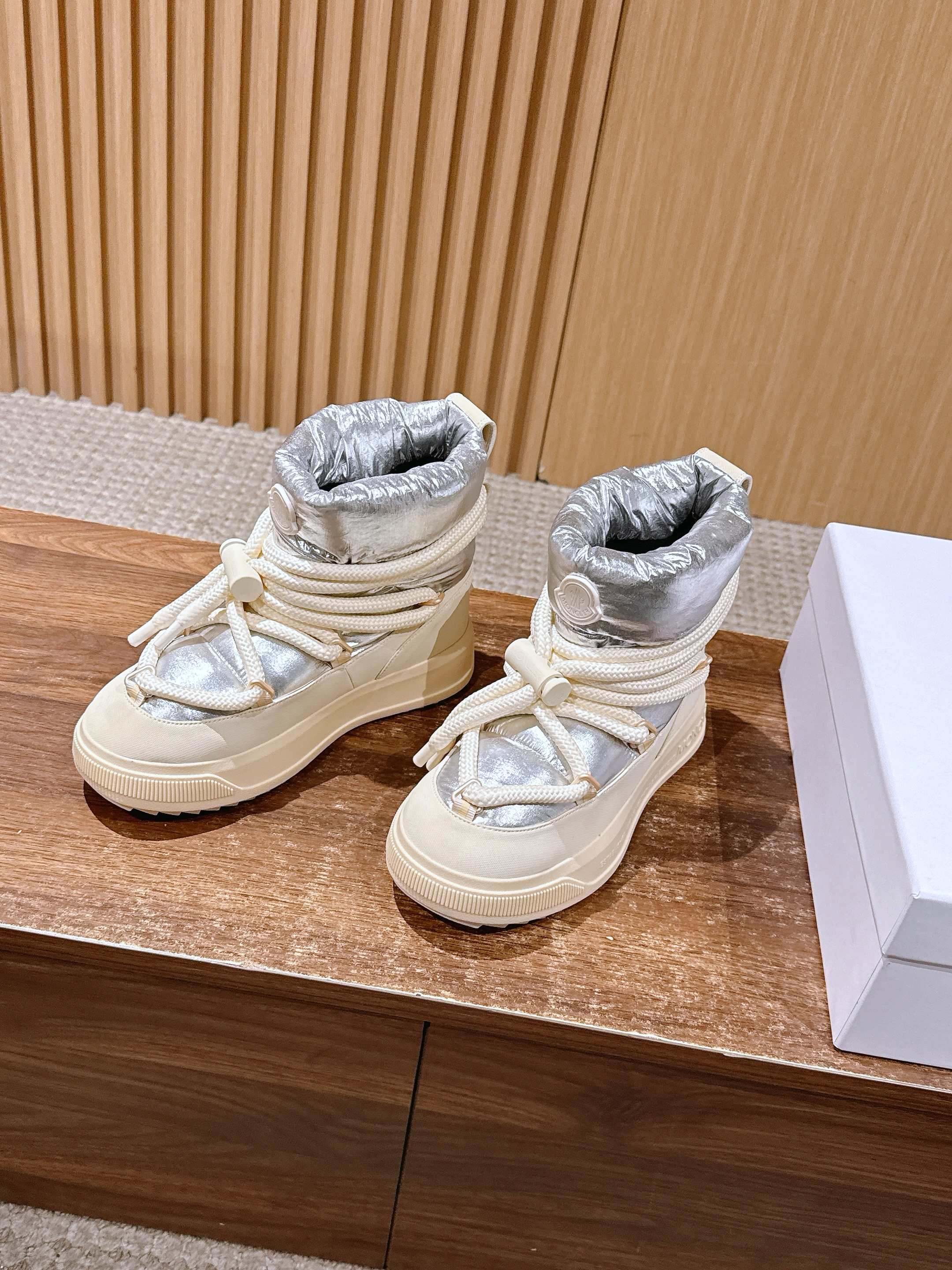Moncler lace-up sneaker boots in silver and cream, angled pair view