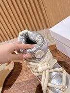 Moncler lace-up sneaker boot with silver padded collar and cream laces, hand holding