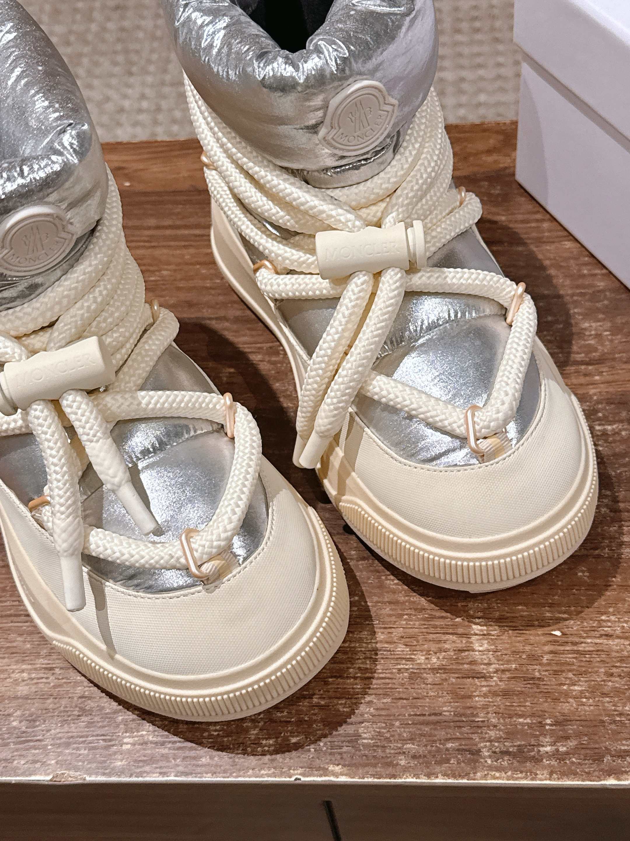 Moncler lace-up sneaker boots detail view of silver panels and cream laces