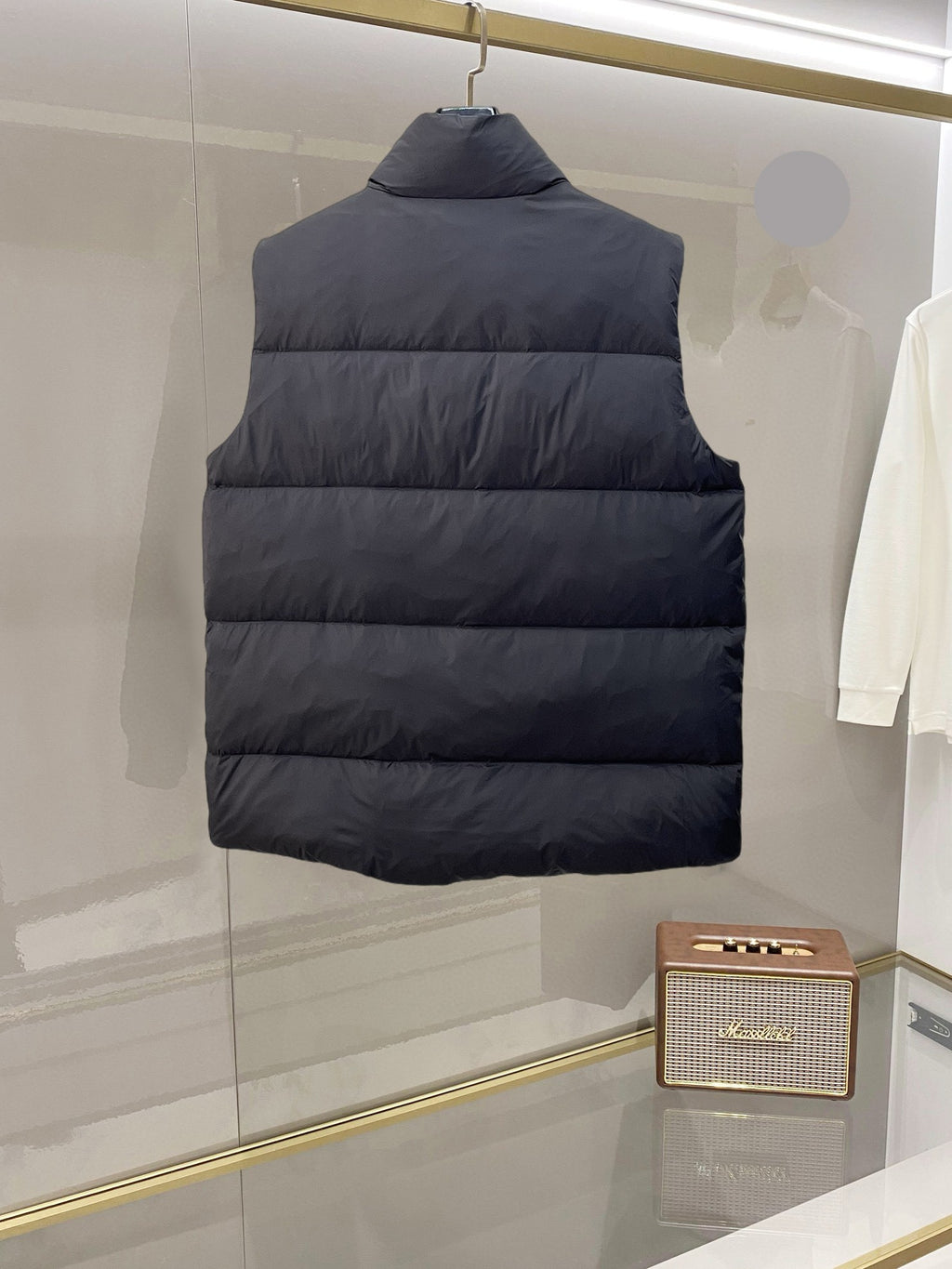 Back view of dark hooded long puffer vest with quilted horizontal panels