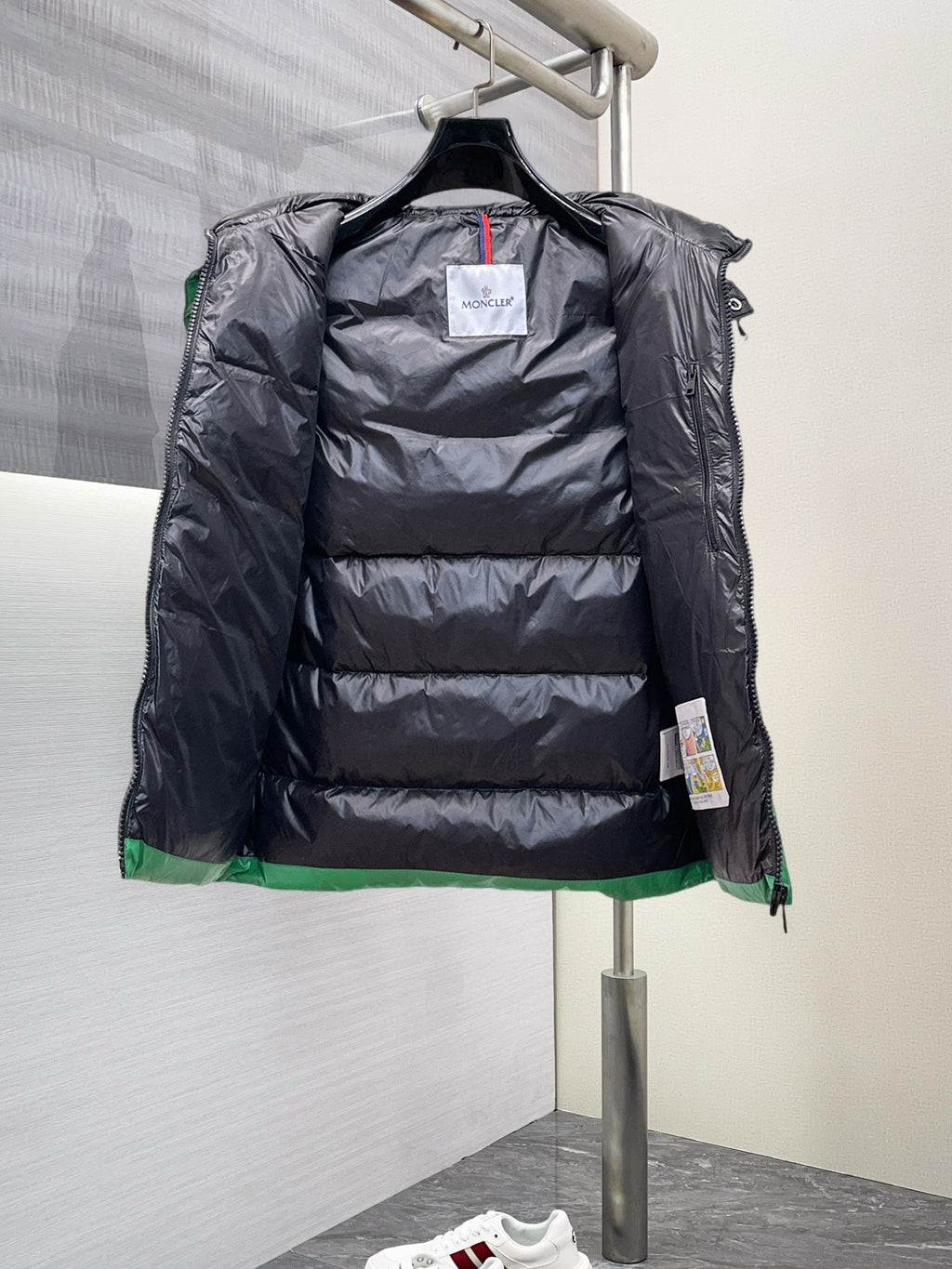 Black interior lining of a puffer vest with front zipper and hood opening