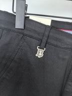Black Burberry trouser waistband with logo charm on the adjustment strap