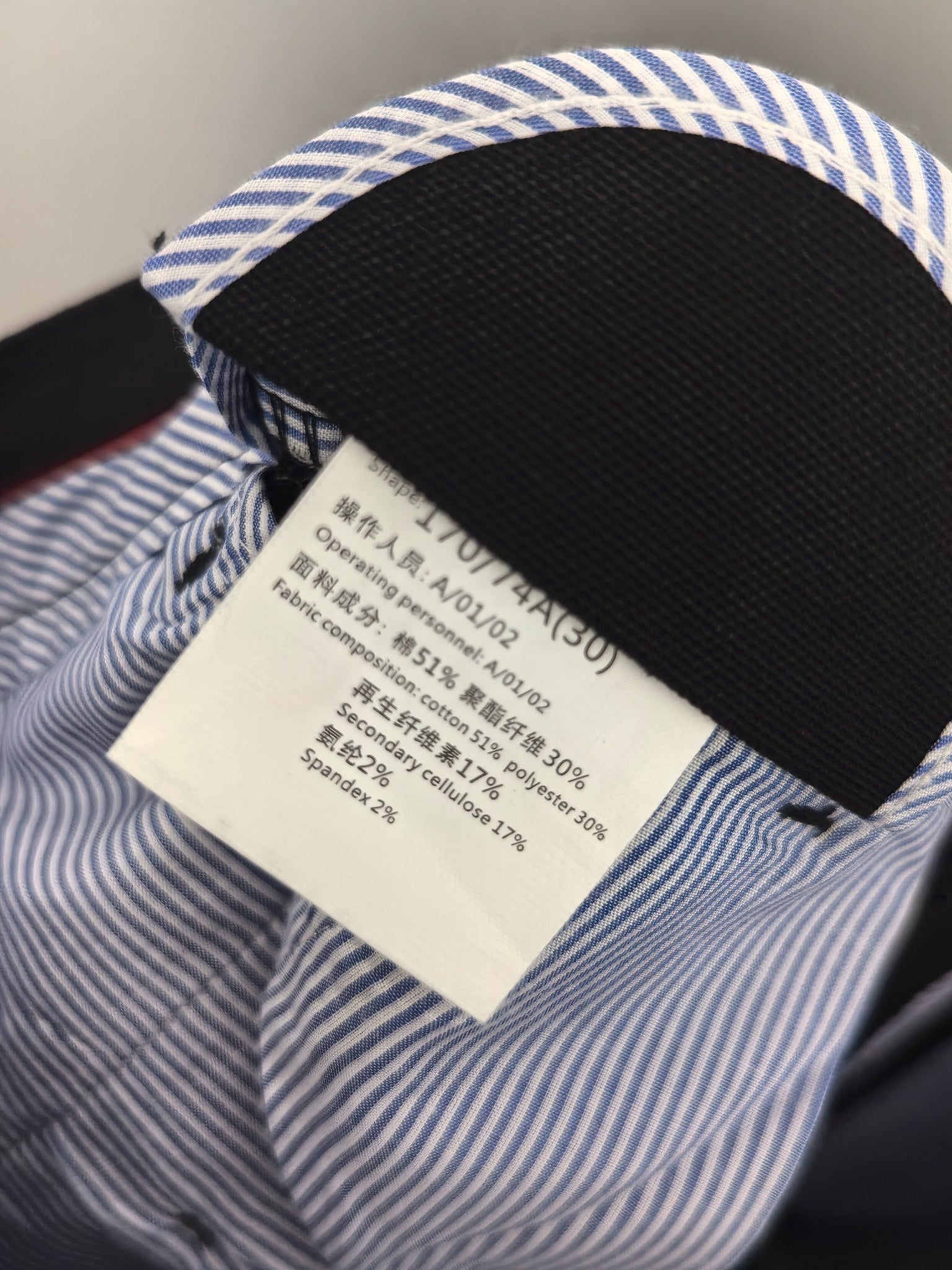 Striped fabric and care label on black Burberry trouser waistband