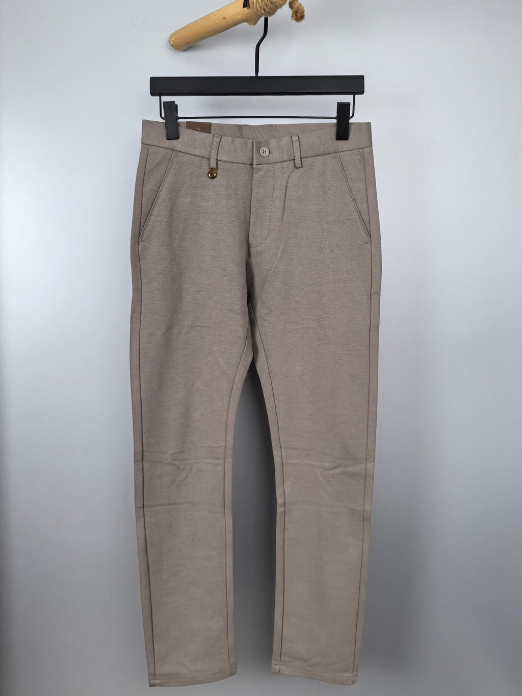 Beige dress pants with belt loops, button closure, and front pleats
