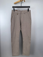 Beige dress pants with belt loops, button closure, and front pleats