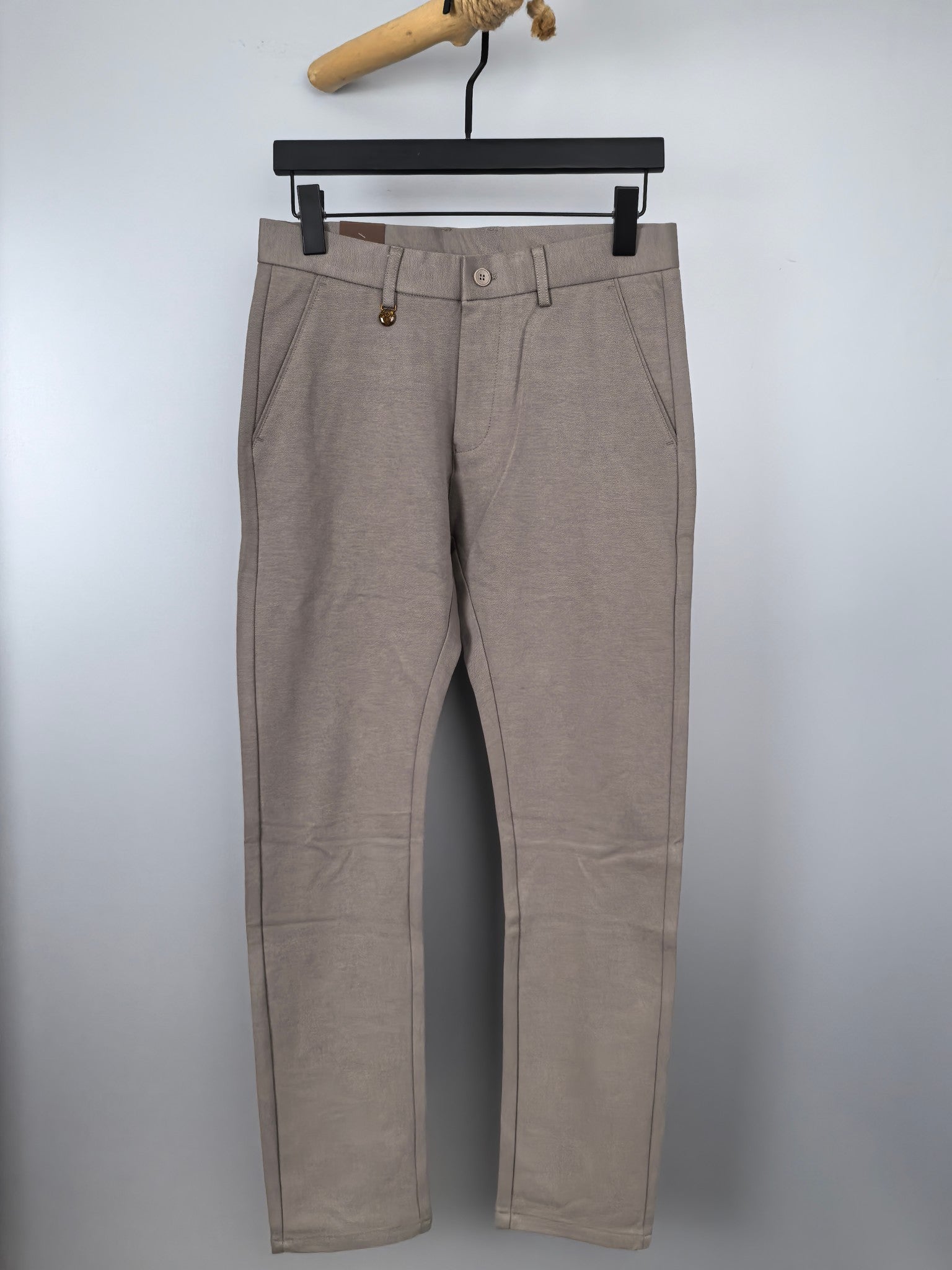 Beige dress pants with belt loops, button closure, and front pleats