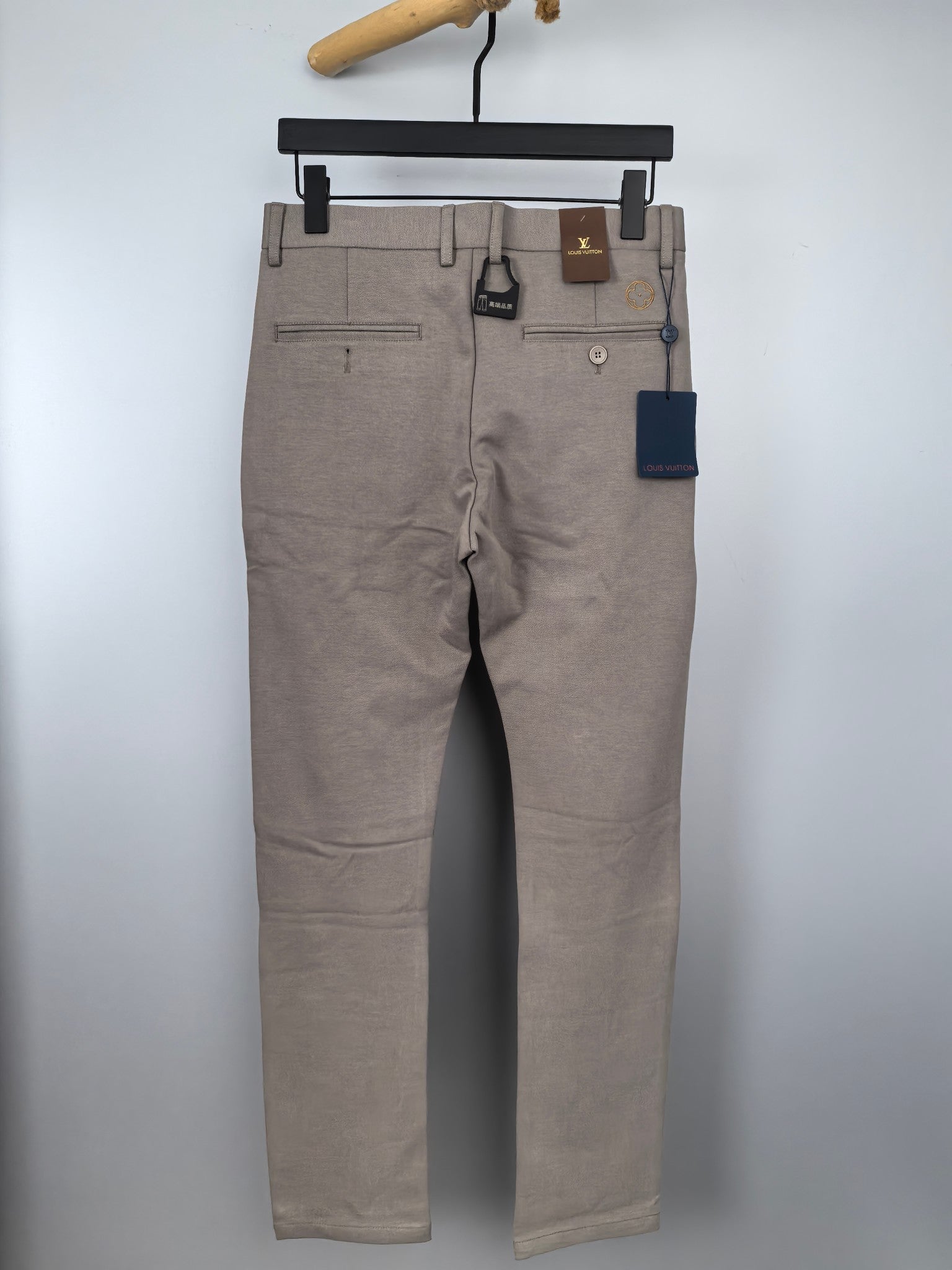 Beige dress pants hanging front view with straight legs and belt loops