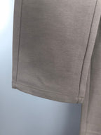 Beige pant hem close-up with straight stitching and side seam