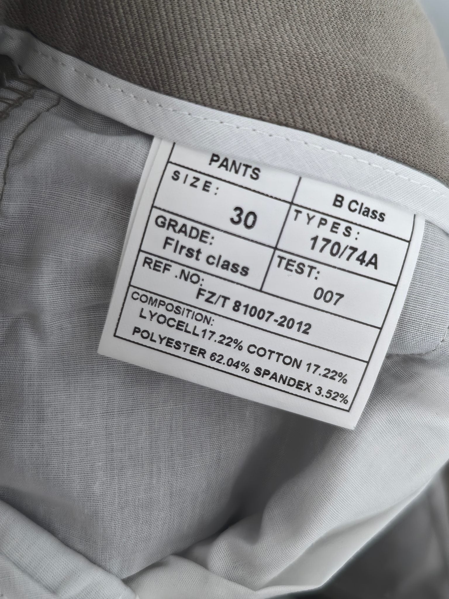 Beige pants size label showing PANTS, Class B, and composition percentages
