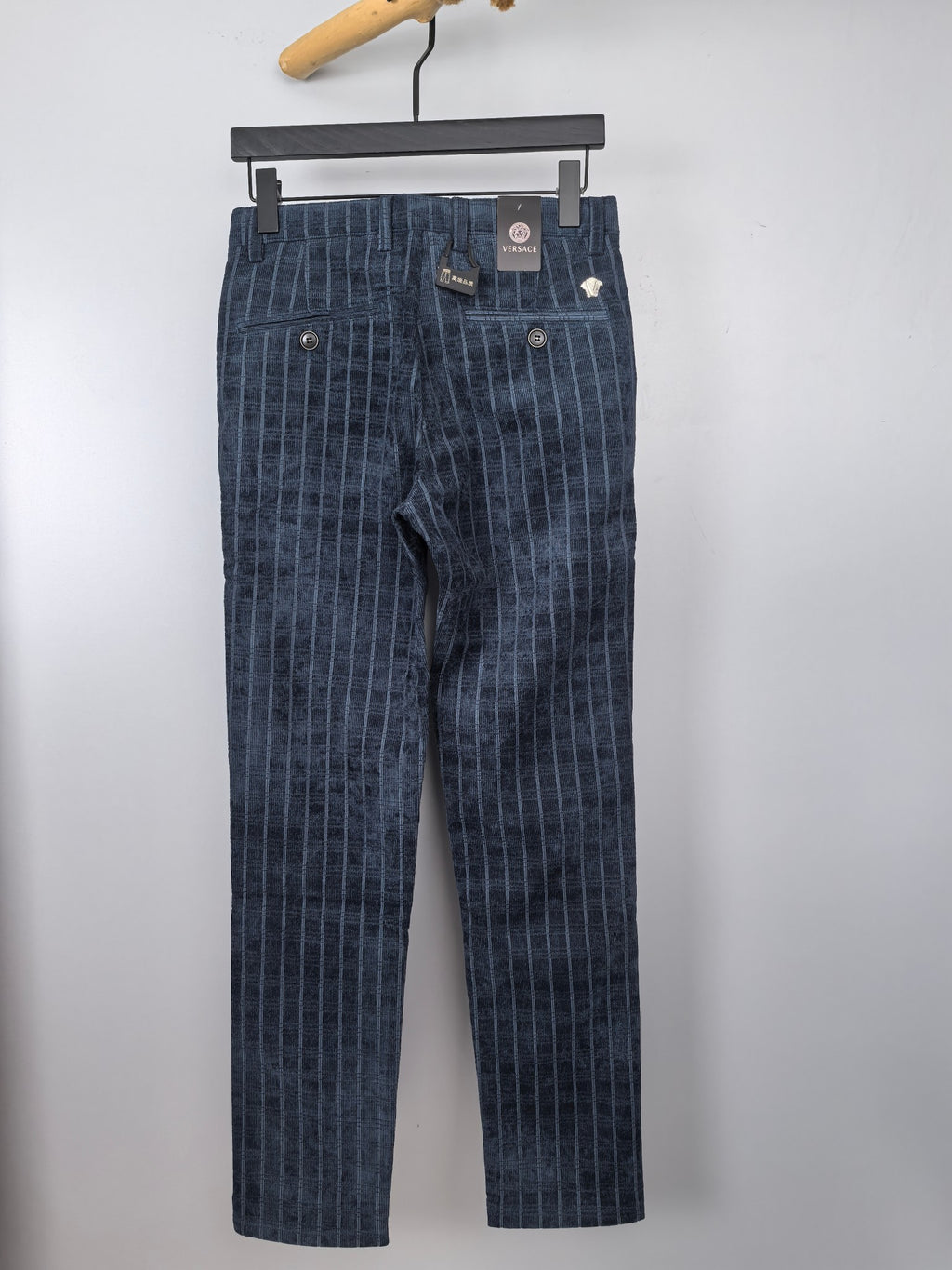 Dark blue check-pattern trousers with button front and belt loops
