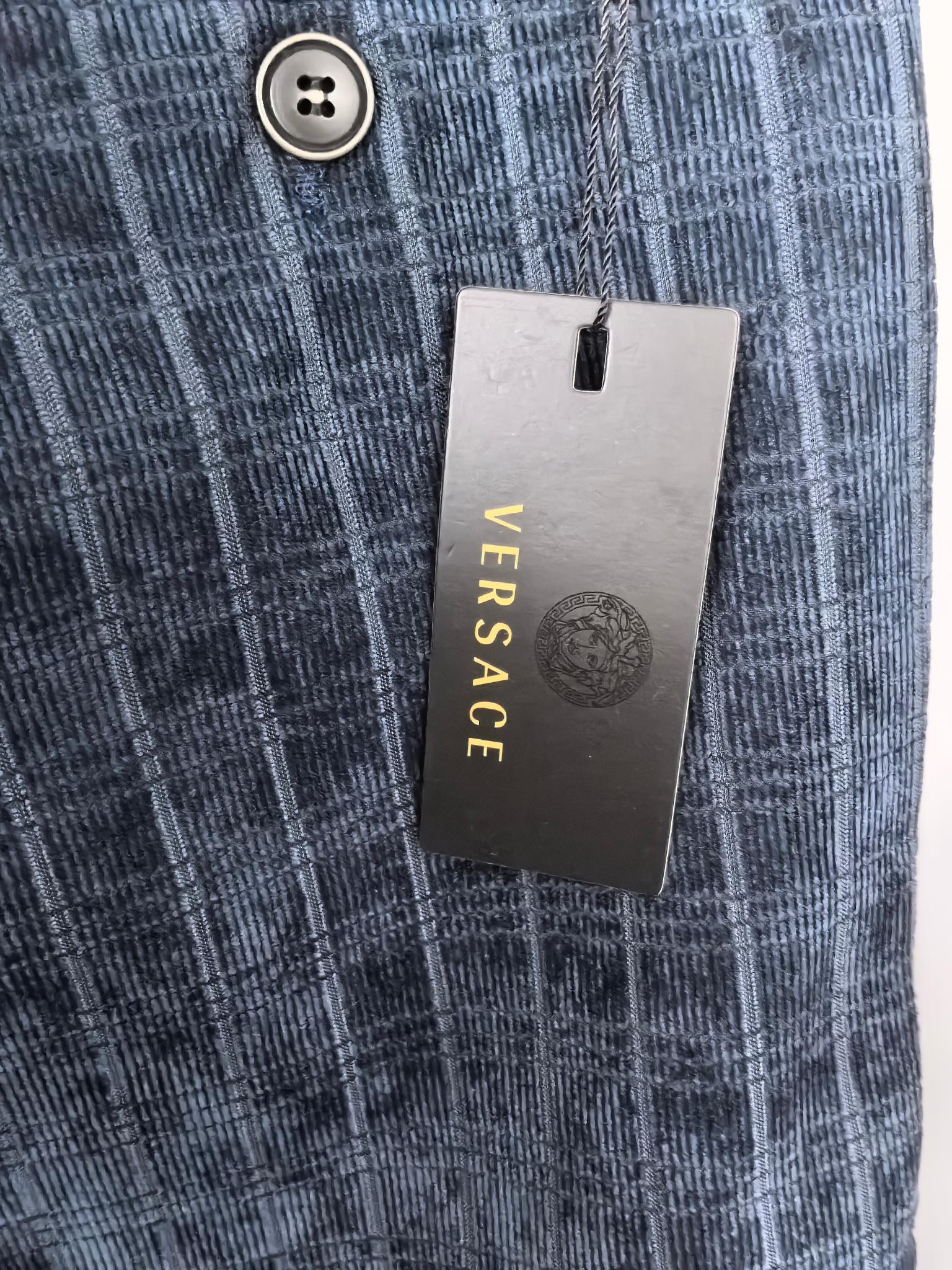 Blue check trousers with button closure and VERSACE hang tag