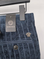 Blue check trousers with VERSACE label, belt loops, and front button