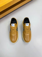 Gold leather sneakers with lace-up front, dark lining, and Burberry check detail