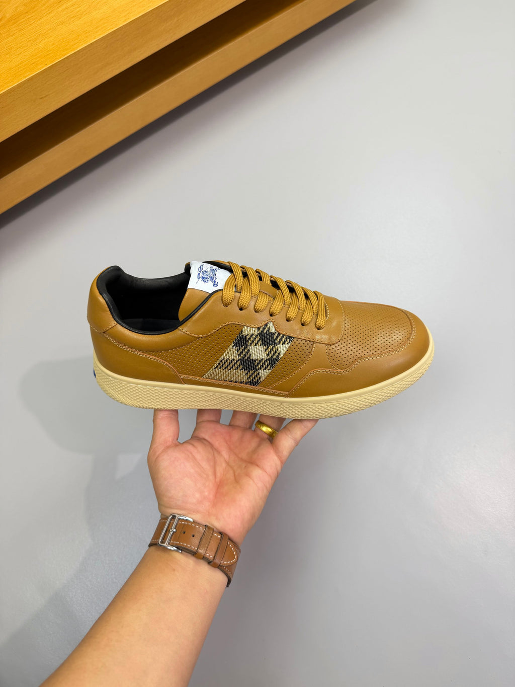 Gold sneaker with lace-up design and Burberry check panel on the side, white sole