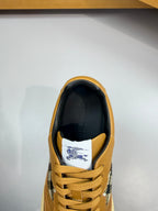 Sneaker heel and lace area with gold upper, dark collar, and Burberry check lining