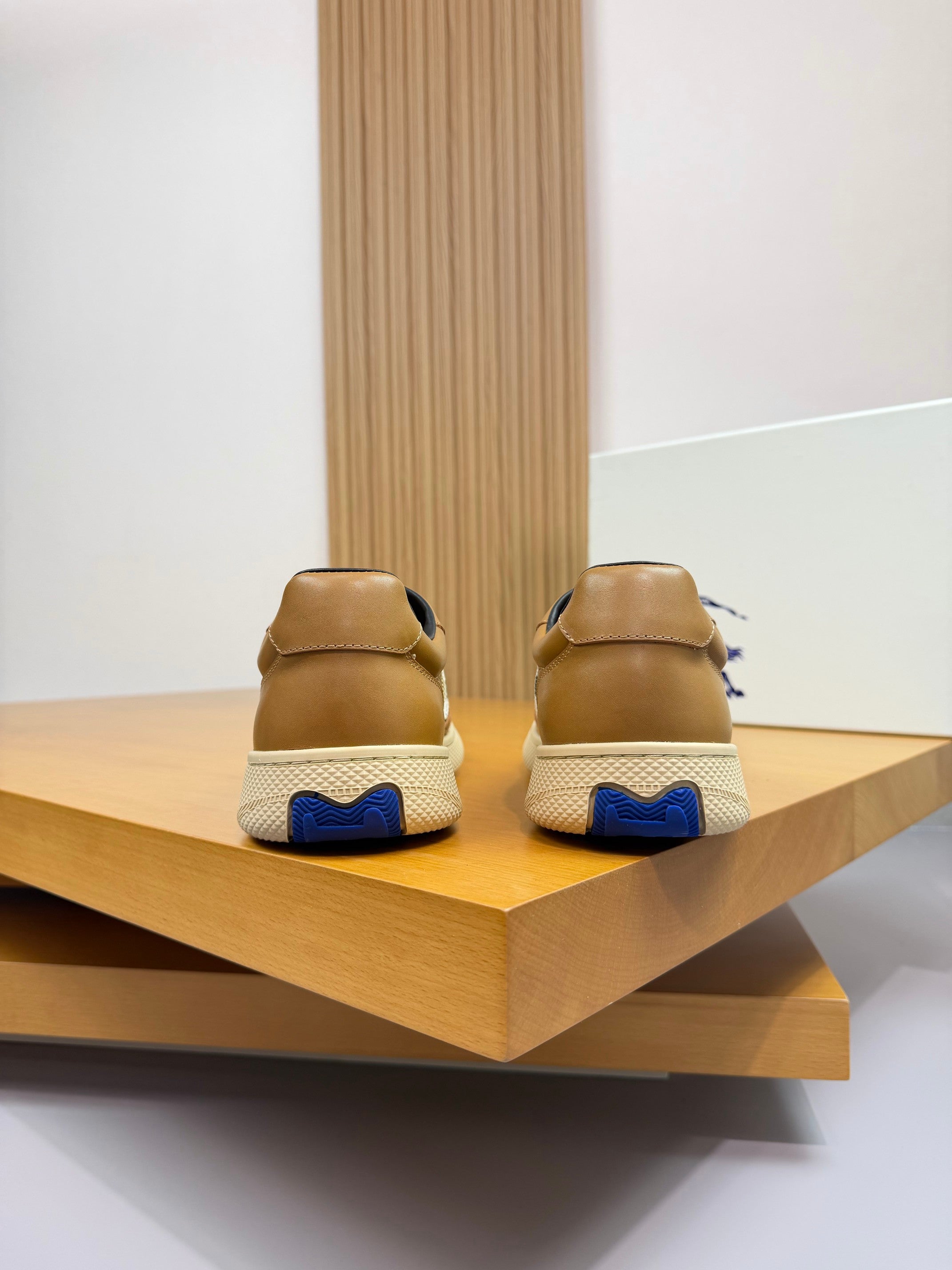 Back view of gold sneakers with blue heel accents and Burberry check detailing