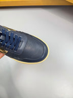 Burberry low-top sneaker close-up in navy with check strap and yellow trim