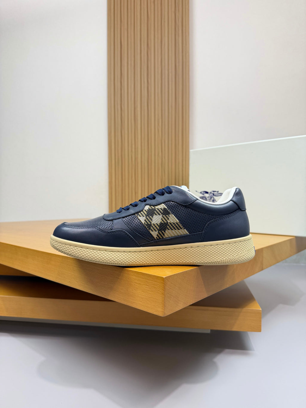 Burberry low-top sneaker in navy with check panel strap and textured white outsole