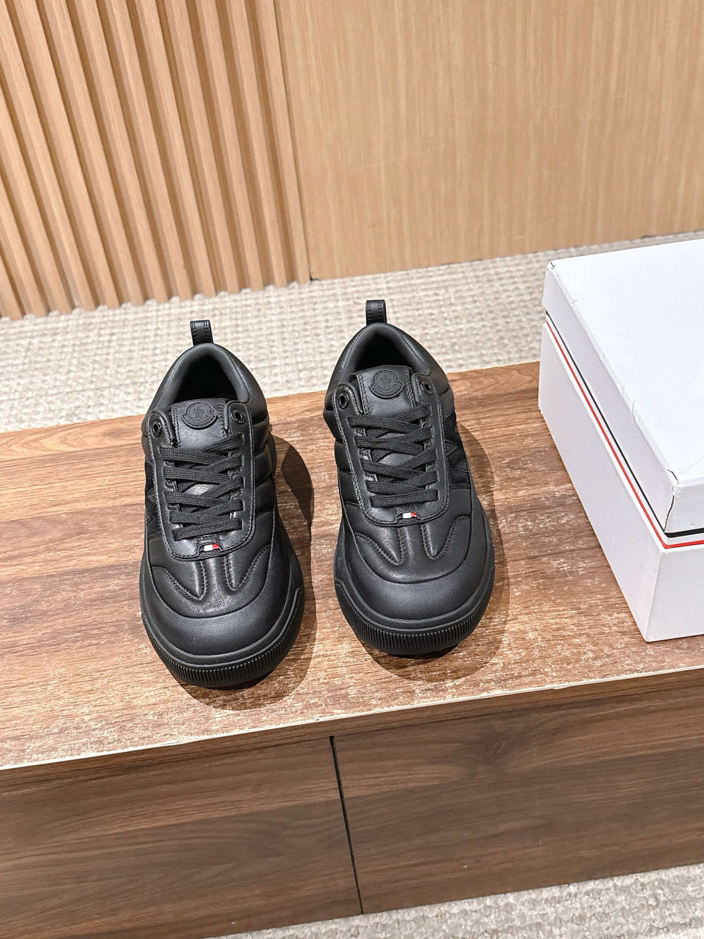 Black Moncler low-top sneakers with lace-up front and padded collar.
