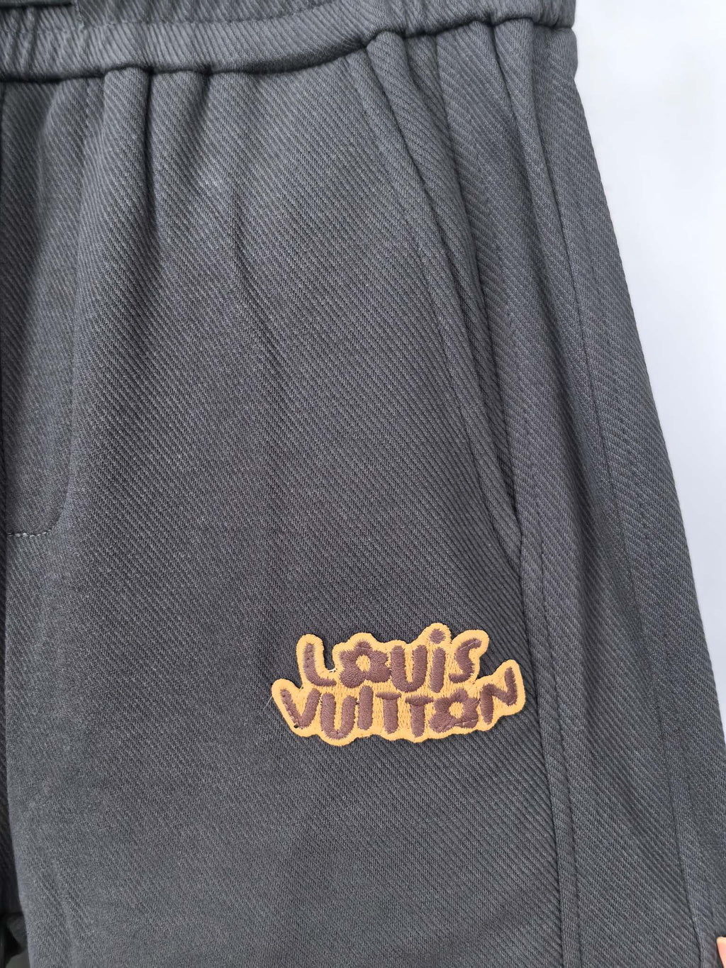 Dark gray Louis Vuitton jogger pants with embroidered logo on front pocket